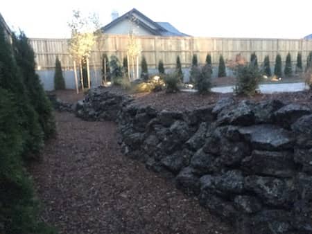 Natural rock retaining wall creates perfect patio placement