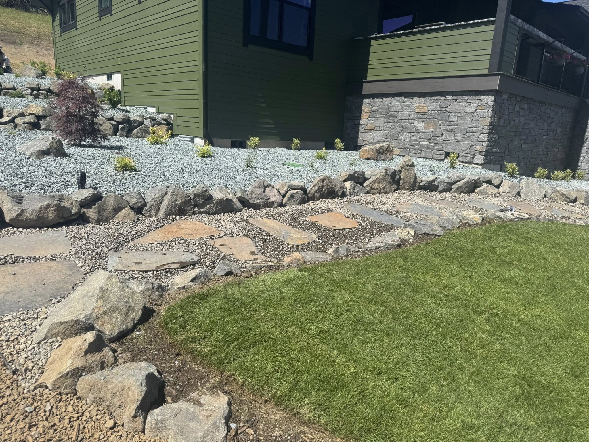 Low maintenance yard using gravel and natural rock acceents.